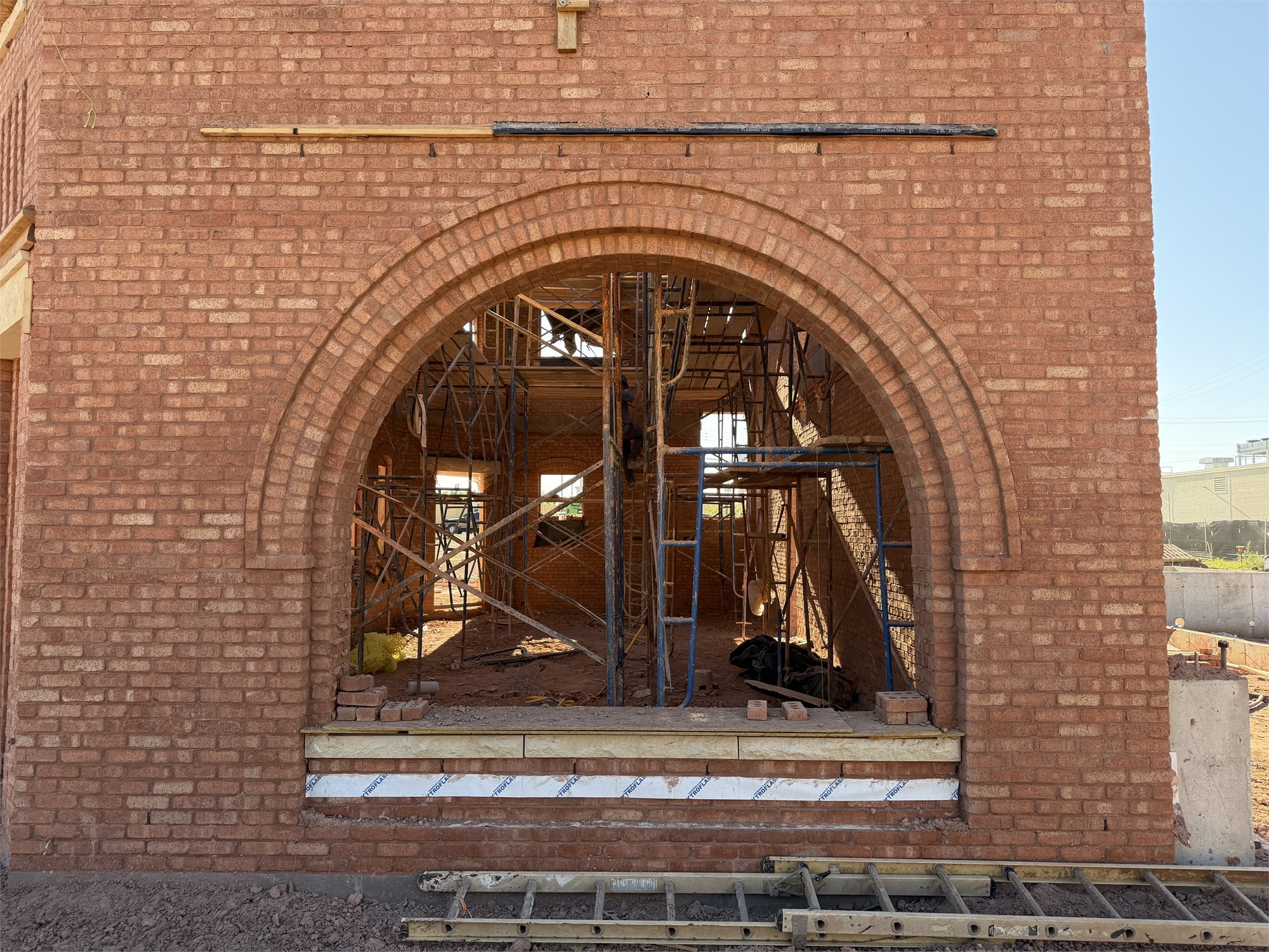 Apollo Workspace under construction — large brick arch opening with internal scaffolding visible inside.