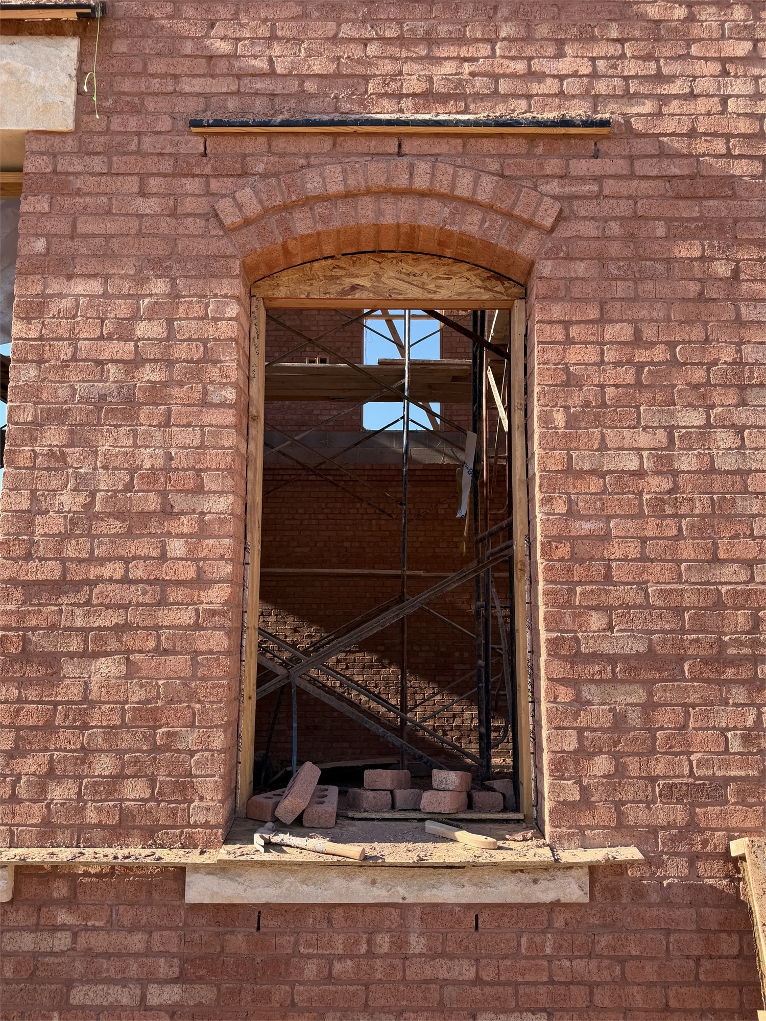 Apollo Workspace under construction — arched brick window opening framed by surrounding brickwork.