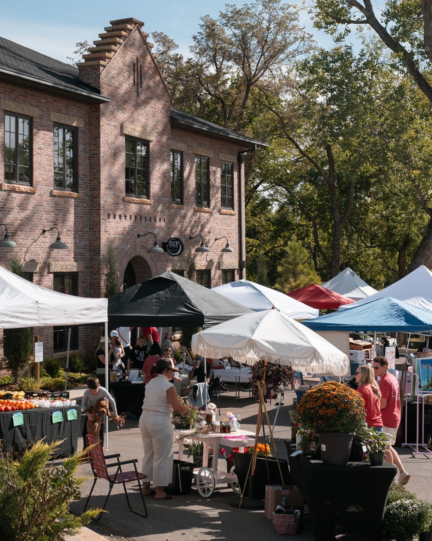 Selah at Carlton Landing — Saturday market in front of the brick mixed-use building Building Culture developed
